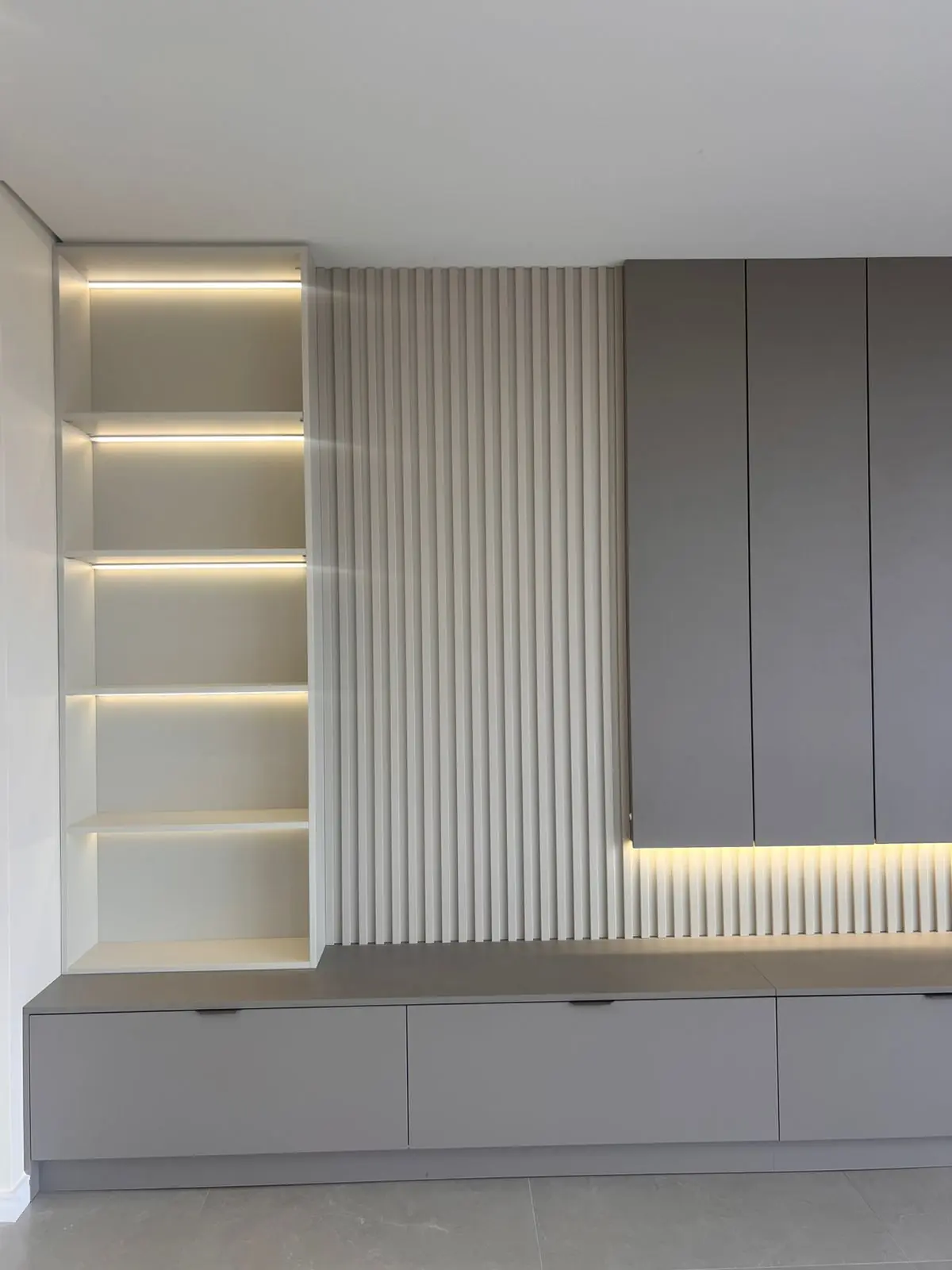Nichos com fita de LED e marcenaria em tom claro em projeto DOMOV