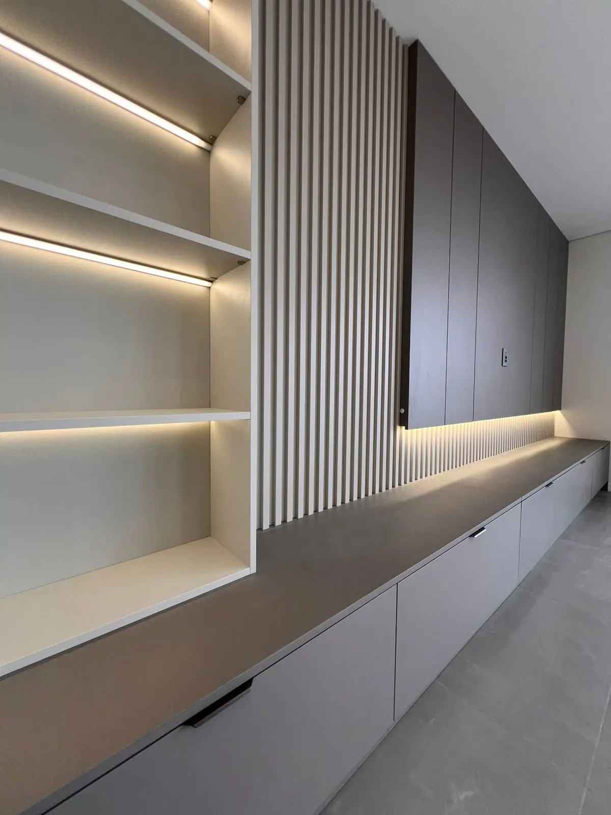 Detalhe de painel ripado com iluminação linear embutida em projeto DOMOV