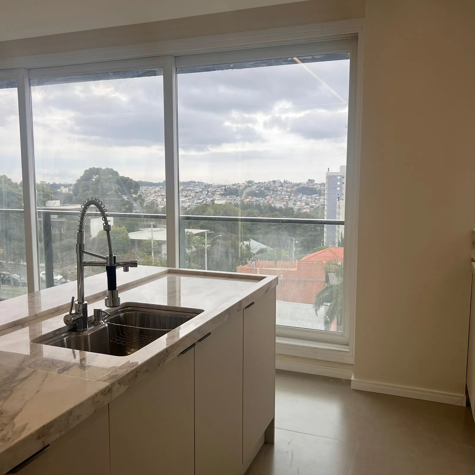 Cozinha planejada com ilha e vista panorâmica pelas janelas em projeto DOMOV